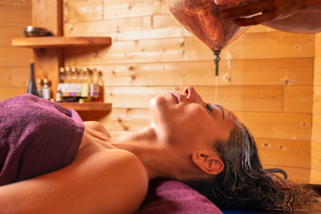 Massages Ayurvédiques 10 Massage ayurvédique, une femme se fait verser des huiles chaudes sur le visage